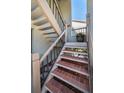 Exterior staircase with tile steps leading to a townhome, enhanced by decorative railings and a potted plant at 3024 Landmark Blvd # 607, Palm Harbor, FL 34684