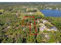 Aerial view of the property, showcasing its wooded surroundings, nearby lake, farmland, and defined property lines at 308 N Smokey Mountain Rd, Seffner, FL 33584
