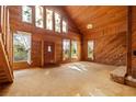 Open-concept living room featuring wood paneling, tall windows, and a vaulted ceiling, providing a warm and inviting space at 308 N Smokey Mountain Rd, Seffner, FL 33584