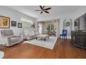 Open living room features hardwood floors, ceiling fan, and access to an enclosed lanai at 4206 Preserve Pl, Palm Harbor, FL 34685