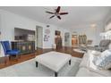 Spacious living room offers hardwood floors, a ceiling fan, and an adjacent kitchen at 4206 Preserve Pl, Palm Harbor, FL 34685