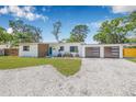 Charming single-story home with modern wood accents, a gravel driveway, and a well-manicured front lawn at 4925 Camellia S Way, St Petersburg, FL 33705
