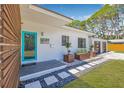 Up close charming home front with a modern blue door, decorative planters, and a stone walkway at 4925 Camellia S Way, St Petersburg, FL 33705