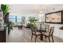 Elegant living room with modern decor, wood floors, and stunning water views, complemented by a stylish dining area at 6265 Sun Blvd # 1201, St Petersburg, FL 33715