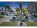 Charming home with lush landscaping, palm trees, and a beautiful sky in the background at 6603 Seabird Way, Apollo Beach, FL 33572