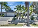 Beautiful home featuring lush landscaping, palm trees, and a well-maintained lawn at 6603 Seabird Way, Apollo Beach, FL 33572