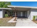 Close-up of the carport featuring decorative posts and a well-maintained lawn at 10426 109Th St, Seminole, FL 33778