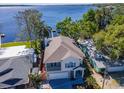 Charming two-story home with a balcony, attached garage, and blue shutters near the water at 1162 Tookes Rd, Tarpon Springs, FL 34689