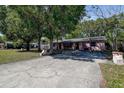 Charming single-story home with a long driveway, complemented by mature trees and well-kept landscaping at 15204 Westminister Ave, Clearwater, FL 33760