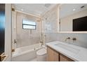 Updated bathroom featuring stylish tilework, bathtub and shower with gold fixtures, and modern sink at 1981 Briarwood St, Dunedin, FL 34698