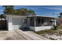 Well-maintained home with an attached garage, screened-in porch, and concrete driveway at 2122 Holiday Dr, Holiday, FL 34691