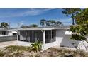 View of the home's side exterior and screened porch, showcasing its classic design and outdoor living space at 2122 Holiday Dr, Holiday, FL 34691