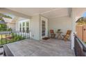 Cozy covered front porch with tile flooring, seating, and a welcoming entrance door at 2328 Dartmouth N Ave, St Petersburg, FL 33713