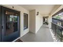 A well-lit exterior entrance with a sturdy black front door, a welcome mat, and a window showing interior spaces at 3610 Magnolia Ridge Cir # 1322/H, Palm Harbor, FL 34684