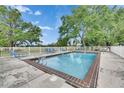 Community pool with a white fence, lounge chairs, and a clear blue sky at 367 Bobby Jones Rd # 367, Sarasota, FL 34232