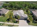 Expansive aerial view of the property showcasing the home's layout, tile roof, and surrounding green landscape at 5409 Conch Shell Pl, Apollo Beach, FL 33572