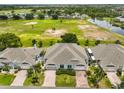 Beautiful aerial view of a home backing onto a scenic golf course and pond at 604 Mcdaniel St, Sun City Center, FL 33573