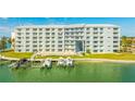 Waterfront condo building featuring boat docks, green space, and community pool at 610 Island Way # 302, Clearwater Beach, FL 33767