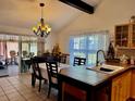 Bright eat-in kitchen featuring honey-colored cabinets, tile floors, and a chandelier over a dining table at 804 Valley Hill Ct, Brandon, FL 33510