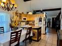 Inviting kitchen featuring honey-colored cabinets, an island and a cozy dining area with a chandelier overhead at 804 Valley Hill Ct, Brandon, FL 33510