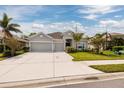 Inviting single-story home with a spacious driveway, a two-car garage, and lush green landscaping at 11335 77Th E St, Parrish, FL 34219