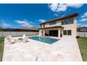 Spacious backyard with a pool, spa, outdoor seating, and covered patio perfect for outdoor entertaining at 11966 Climbing Fern Ave, Riverview, FL 33579