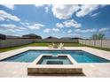 Backyard oasis with a large pool, spa, and lounge area surrounded by a spacious lawn and a white fence at 11966 Climbing Fern Ave, Riverview, FL 33579