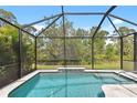 Beautiful in-ground pool with a screened enclosure and lush green surroundings at 12379 Amica Loop, Venice, FL 34293