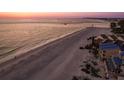 Scenic aerial view of beachfront homes and a sandy shoreline at sunset at 12512 1St W St # 2, Treasure Island, FL 33706