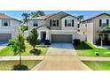 Charming two-story home featuring a well-manicured lawn, lush landscaping, and attached two-car garage at 12841 Wildflower Meadow Dr, Riverview, FL 33579