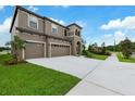 Beautiful home boasts a three-car garage, a well manicured lawn, and ample driveway space at 14403 Woodland Spur Dr, Lithia, FL 33547