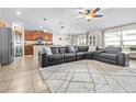 Open-concept living room with tile flooring, a cozy seating area, and seamless flow to the kitchen and dining at 207 Archcliffe Point Pl, Dover, FL 33527