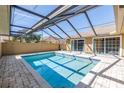 Inviting screened-in pool with brick pavers and sliding glass doors for easy indoor-outdoor living at 2312 Heron Cir, Clearwater, FL 33762