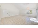 Open living space with tile floors, high ceilings, a modern light fixture, and access to the outdoors at 2581 Forest Run Ct, Clearwater, FL 33761