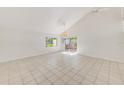 Bright living room with tile flooring, high ceilings, a ceiling fan, and a sliding glass door to the outside at 2581 Forest Run Ct, Clearwater, FL 33761
