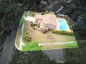 Aerial view of a home with an in-ground swimming pool surrounded by lush greenery and fencing at 3103 Taragrove Dr, Tampa, FL 33618