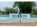 Community sign reading 'Indigo Pond' amidst lush greenery and a decorative water feature at 3629 Indigo Pond Dr # 3629, Palm Harbor, FL 34685