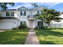 Charming two-story home with manicured lawn, brick pathway, and a welcoming pink front door at 4105 W Corona St, Tampa, FL 33629