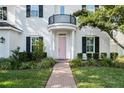 Close up of the charming two-story home, manicured lawn and welcoming pink front door at 4105 W Corona St, Tampa, FL 33629