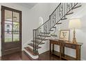 Elegant foyer with dark wood floors, decorative iron staircase, and console table at 4310 W Sevilla St, Tampa, FL 33629