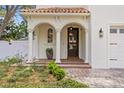 Charming front porch with arched columns, a dark wood door, and brick flooring at 4310 W Sevilla St, Tampa, FL 33629