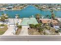 Aerial view of a home with a green roof, surrounded by palm trees and waterfront access at 540 115Th Ave, Treasure Island, FL 33706
