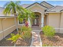 Inviting front entry featuring a brick path leading to an arched entryway with a decorative glass door at 6181 9Th Avenue Ne Cir, Bradenton, FL 34212