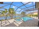 Screened-in pool area with a hot tub and views of a tranquil lake surrounded by palm trees at 6181 9Th Avenue Ne Cir, Bradenton, FL 34212