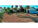 Charming single-story home featuring an attached two-car garage, with desert landscaping and palm trees at 6526 Senegal Palm Way, Apollo Beach, FL 33572