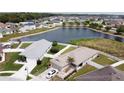 Aerial view shows a waterfront home with an attached two-car garage and a white fence at 6632 Laxey Ct, Zephyrhills, FL 33541