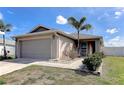 Charming single-story home with a two-car garage, lush landscaping, and a well-maintained lawn at 6632 Laxey Ct, Zephyrhills, FL 33541