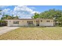 The house features an inviting front yard, white brick exterior, and ample parking space at 904 Woodland Dr, Seffner, FL 33584