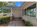 Inviting front porch with stone accents, beautiful landscaping, and a stylish entrance at 9044 Lynwood Dr, Seminole, FL 33772