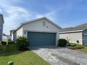 Lovely single-level home featuring a teal two-car garage and manicured lawn at 11833 Clare Hill Ave, Riverview, FL 33579